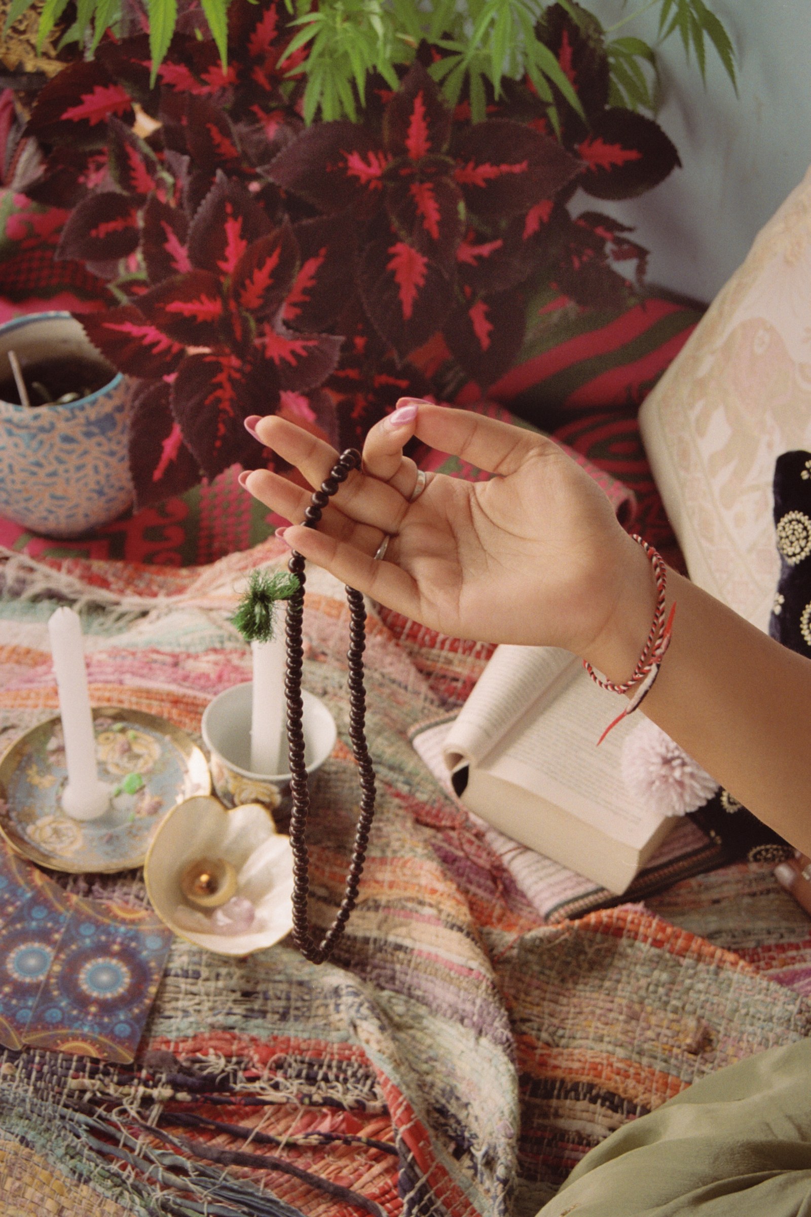 A quiet ritual space with prayer beads, books and candles
